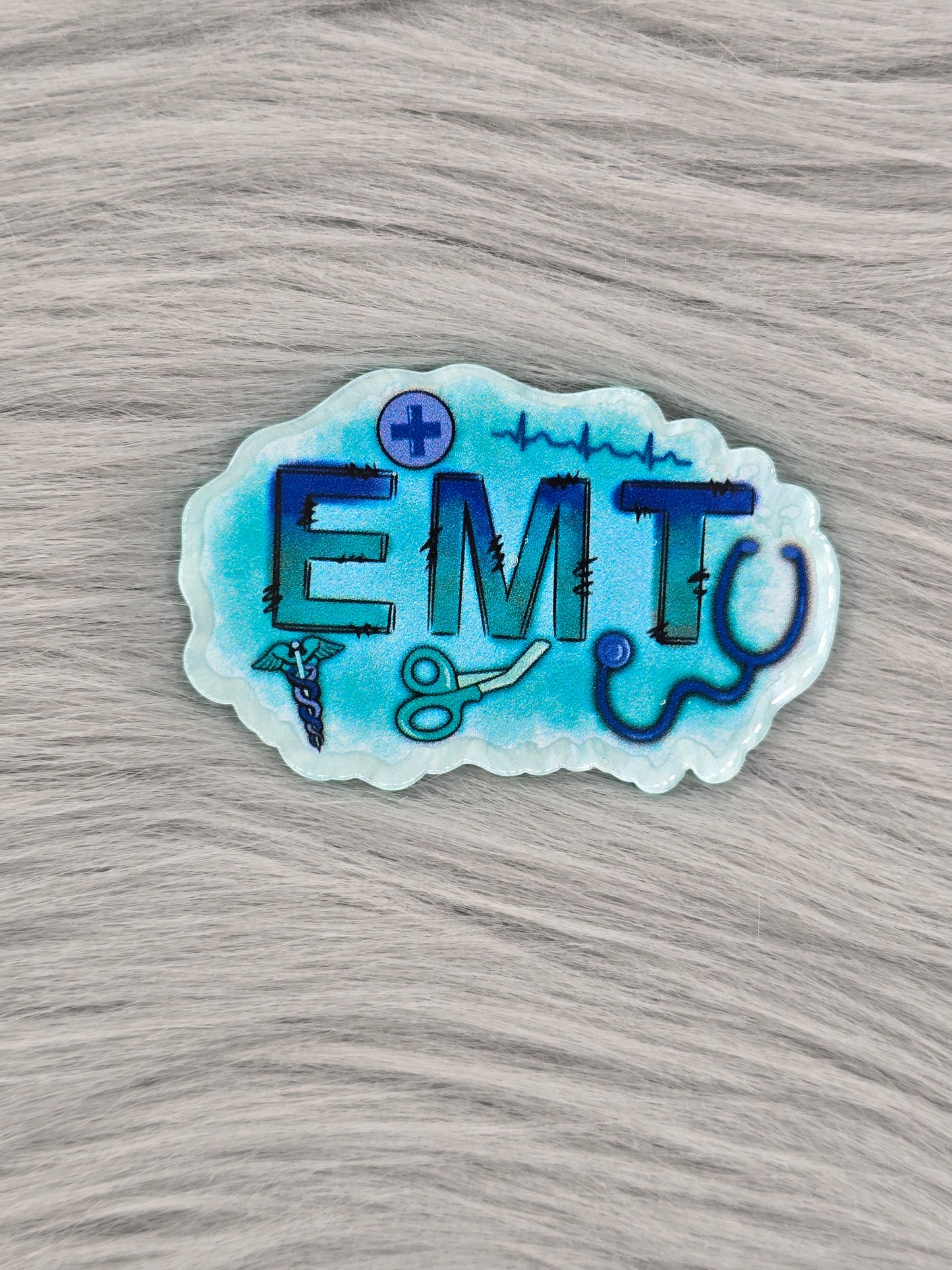 Blue/White acrylic flatback with the letters 'EMT' with medical pictures