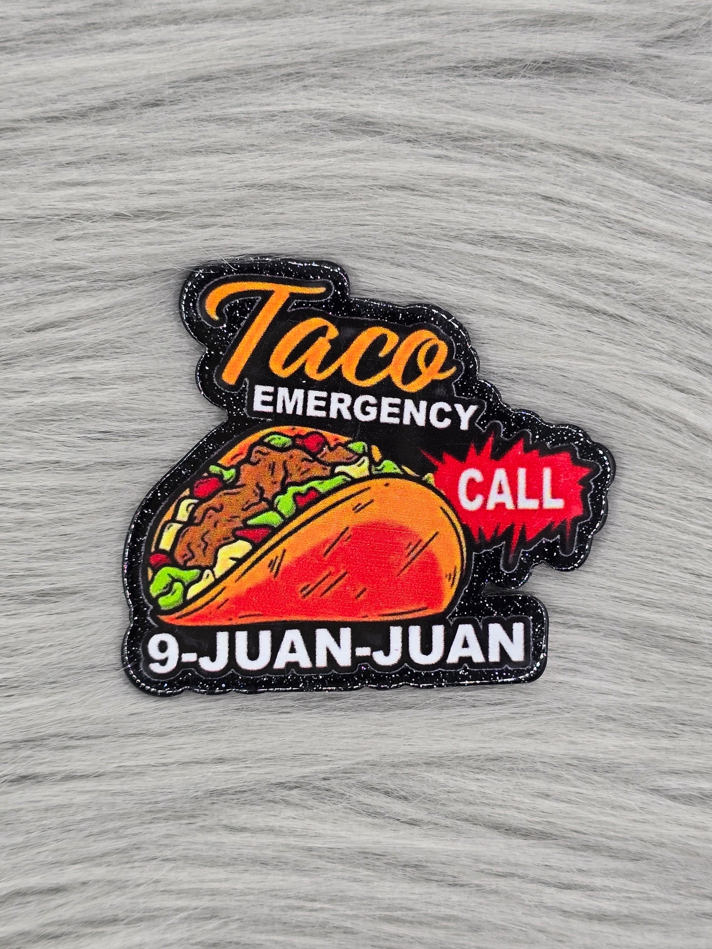 Black Glitter flatback with the words "Taco Emergency Call 9-Juan-Juan" with a picture of a taco