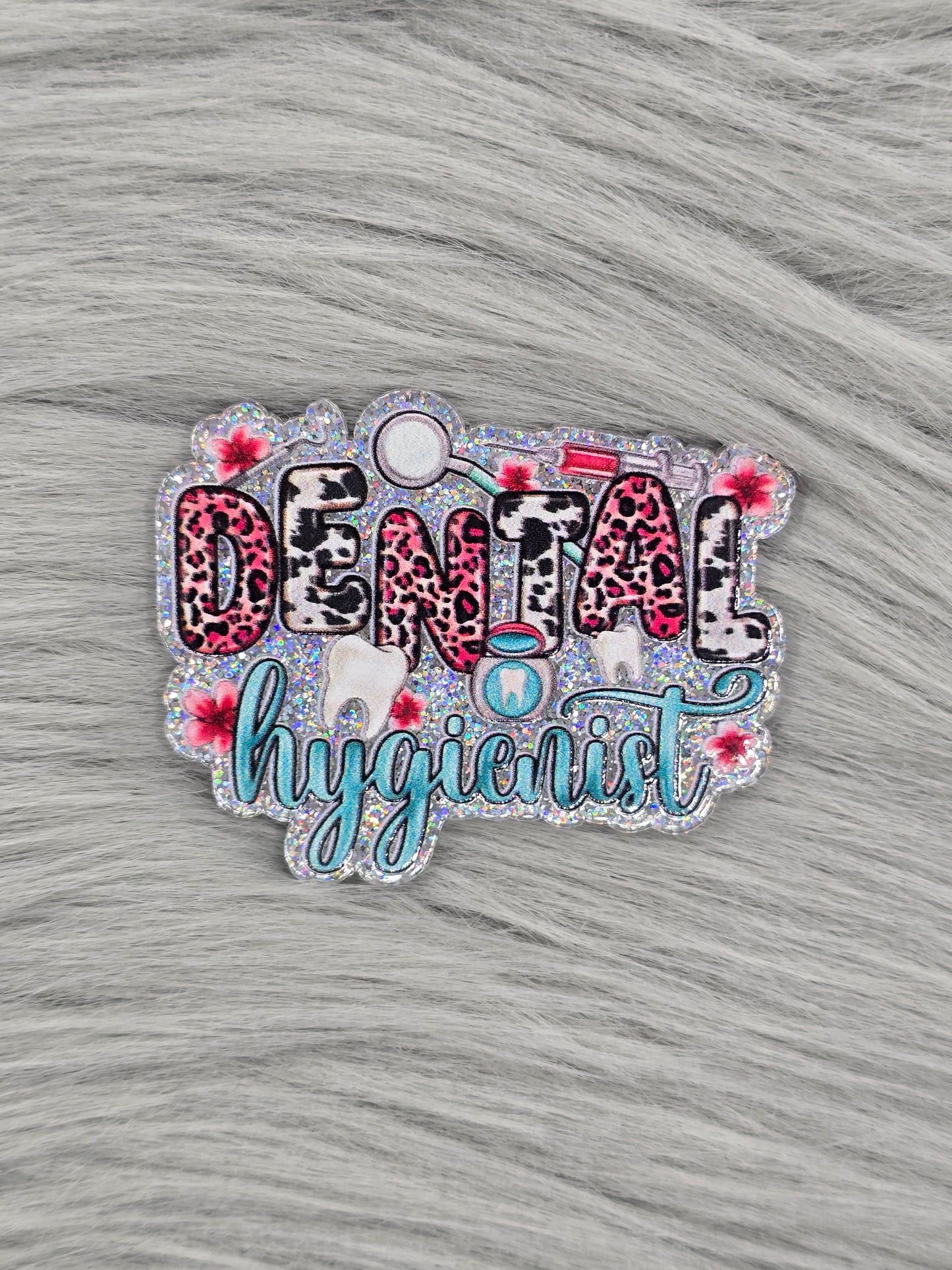 Glitter silver acrylic flatback with the word Dental in animal print and the word hygienist in light green with dental pictures