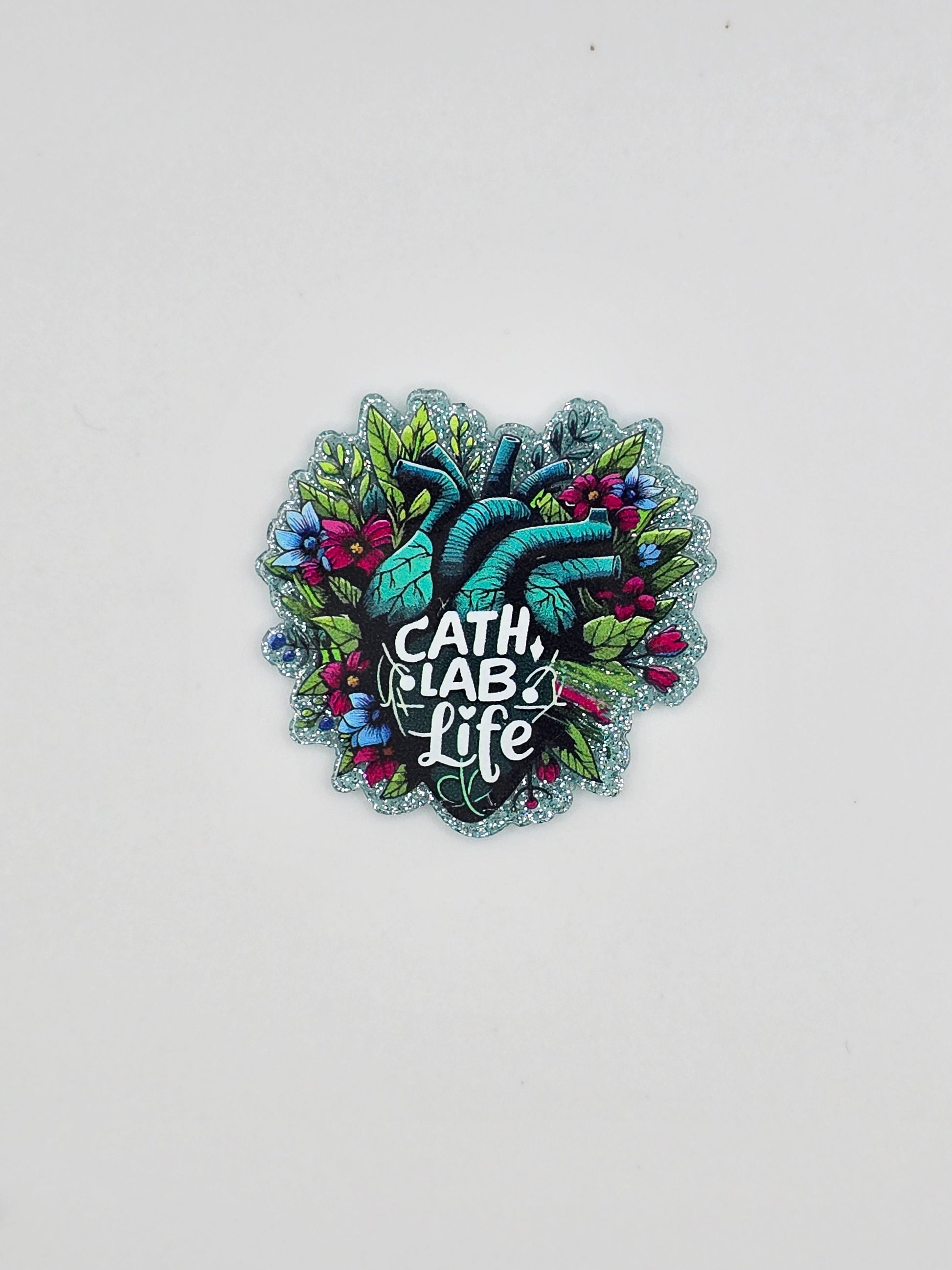 A green heart with flower and leaves around it and in the middle it states "cath lab life" on a glitter background