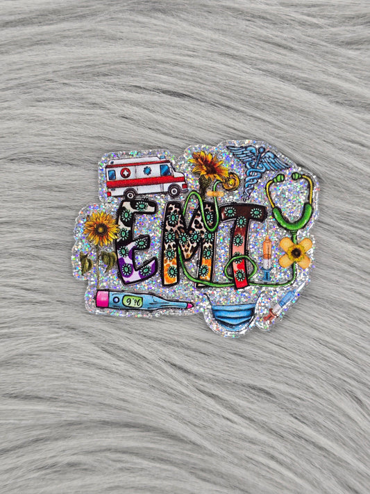 Silver glitter background acrylic flatback with the letters 'EMT' with medical items and yellow flowers