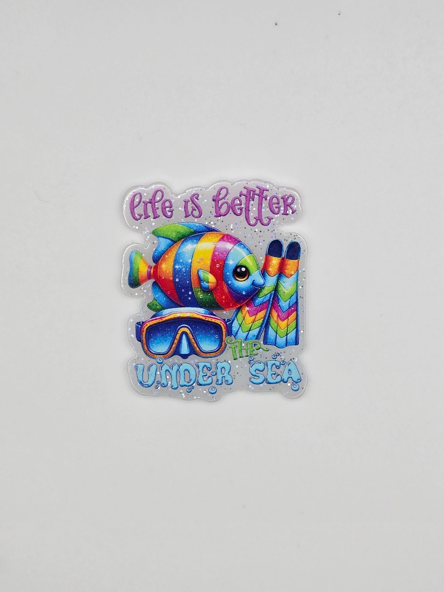 Colorful fish design with Life Is Better Under The Sea on a white glitter background flatback