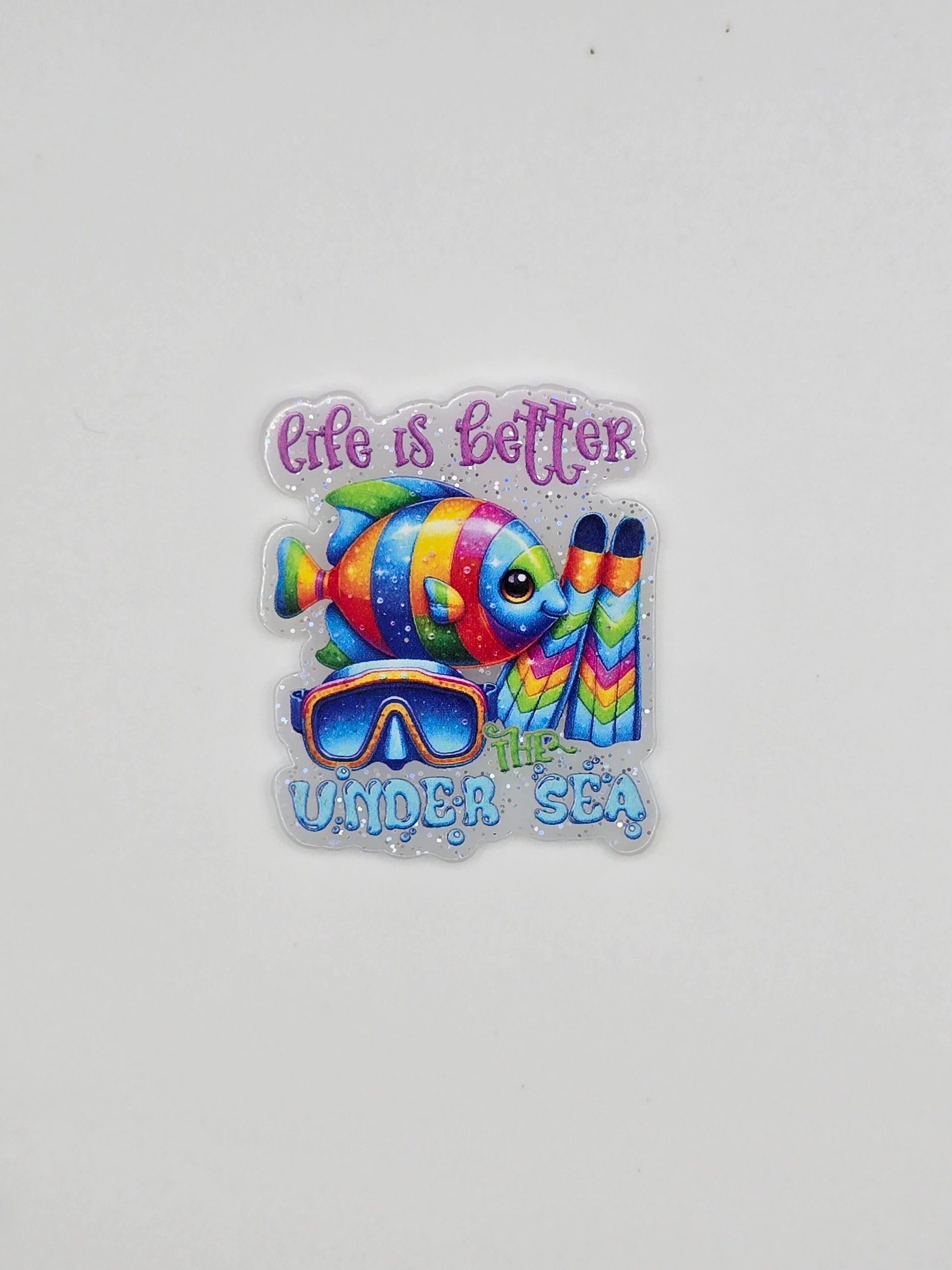 Colorful fish design with Life Is Better Under The Sea on a white glitter background flatback
