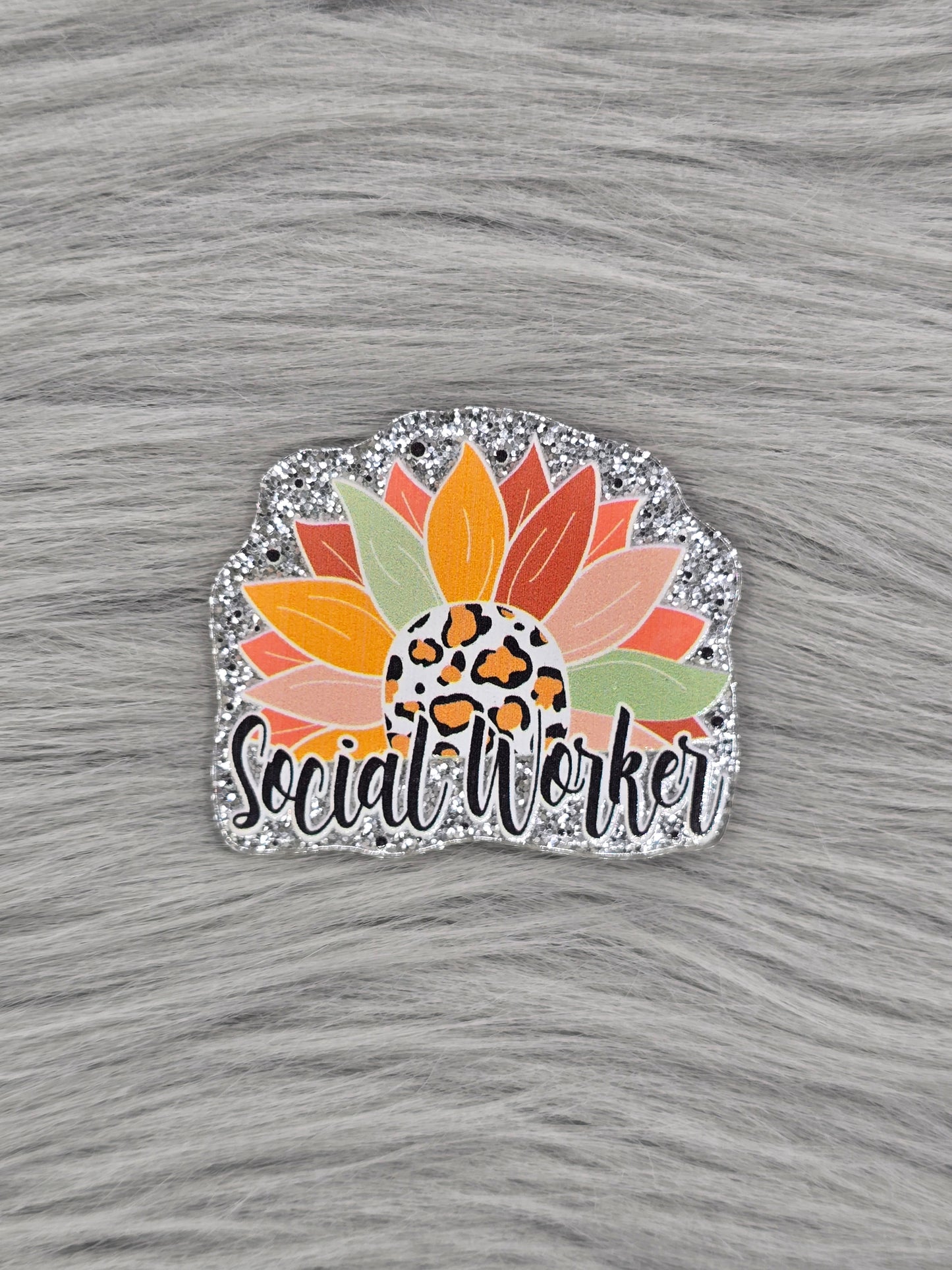 Silver glitter acrylic flatback with a half flower and the bottom says 'Social Worker' in black
