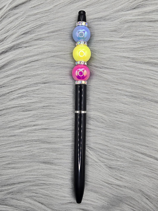 Black beadable pen with silver rhinestone spaces and a pink, yellow and blue bead