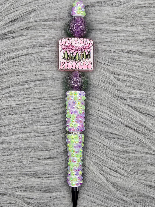 Beadable green and purple rhinestone pen. Acrylic focal that says "Just A Girl Who Loves Pickles" and 2 beads that are half purple/half green