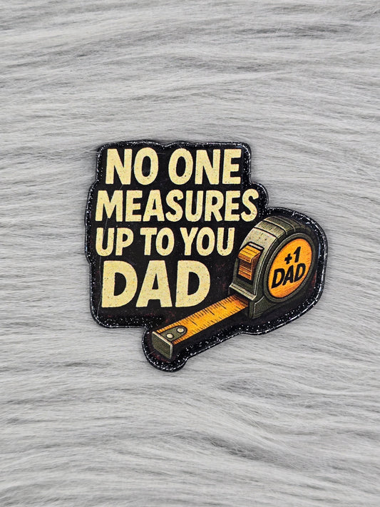 Black acrylic flatback with a tape measure and the words in yellow that say "No One Measures Up To You Dad"