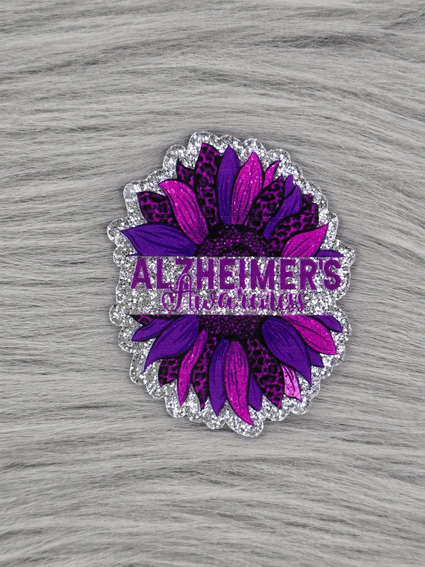 Purple flower with purple words in the middle that say "Alzheimer's Awareness"