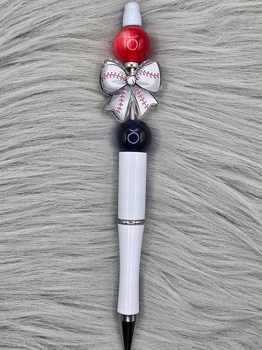 White beadable pen with a white baseball bow acrylic focal and a dark blue and red acrylic bead