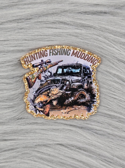 Gold glitter flatback with the words "Hunting Fishing Mudding" with pictures of a riffle, fish and Jeep