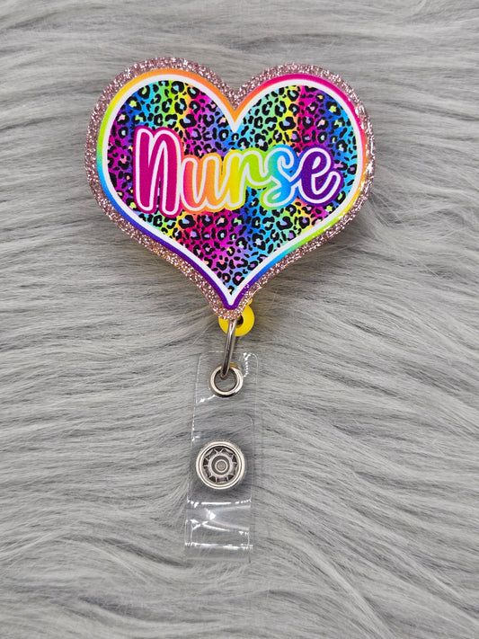 Heart shaped acrylic flatback with a rainbow leopard background and the word nurse in rainbow