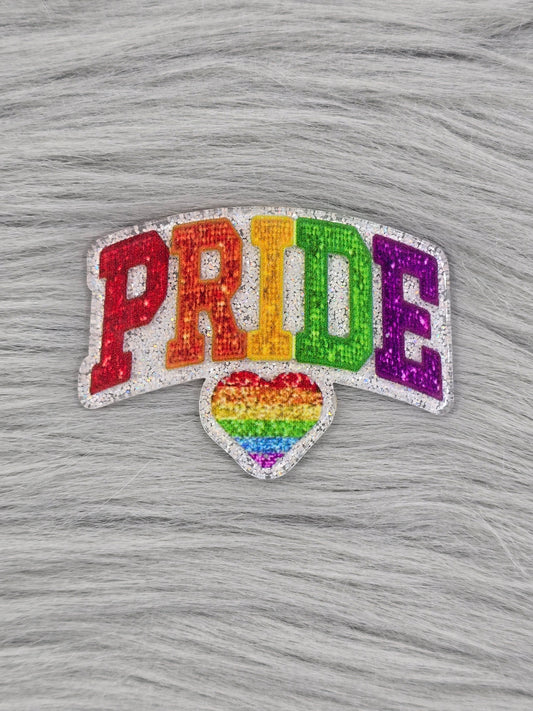 Silver glitter flatback with the word "PRIDE" in rainbow colors with a rainbow heart at the bottom
